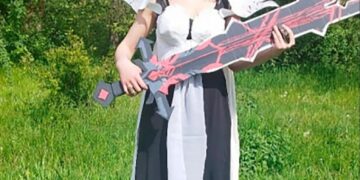Mujer en cosplay sosteniendo una gran espada.