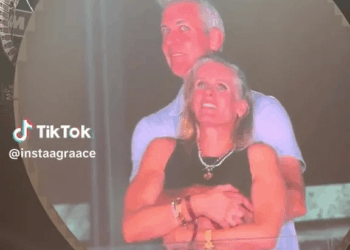 Pareja abrazando en una pantalla grande.