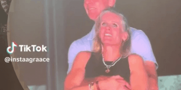 Pareja abrazando en una pantalla grande.