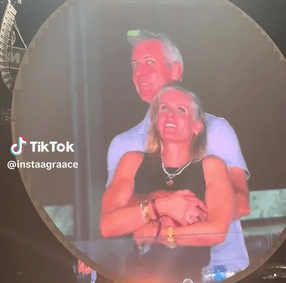 Pareja abrazando en una pantalla grande.