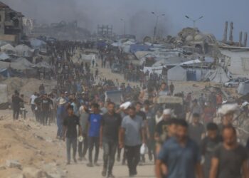 Los palestinos que llevan ayuda a través de un área dañada.