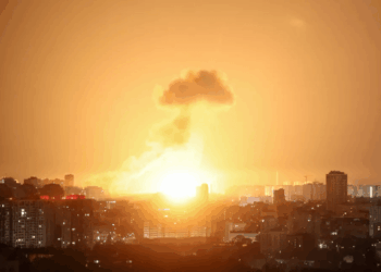 Gran explosión sobre una ciudad por la noche.