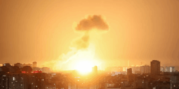 Gran explosión sobre una ciudad por la noche.