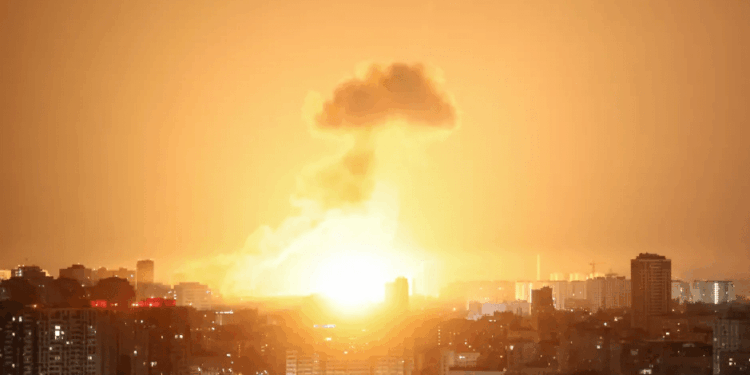 Gran explosión sobre una ciudad por la noche.