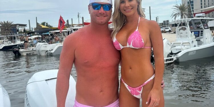 Pareja con trajes de baño posando en un bote.