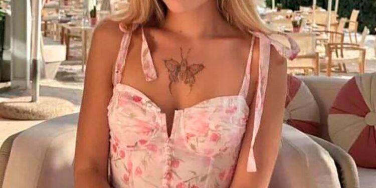 Mujer con vestido floral sentado al aire libre.