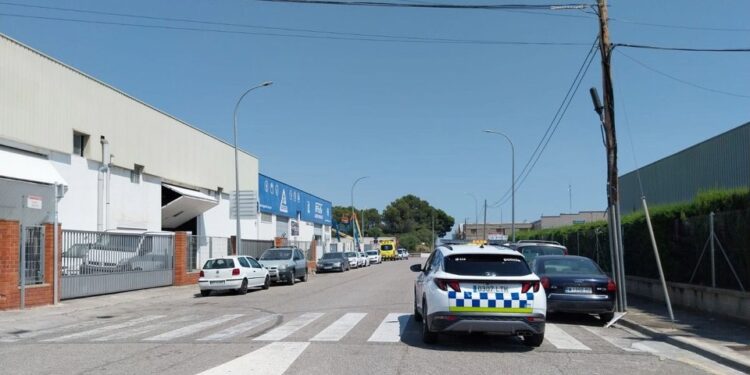 Escena callejera de autos estacionados cerca de un vehículo policial.