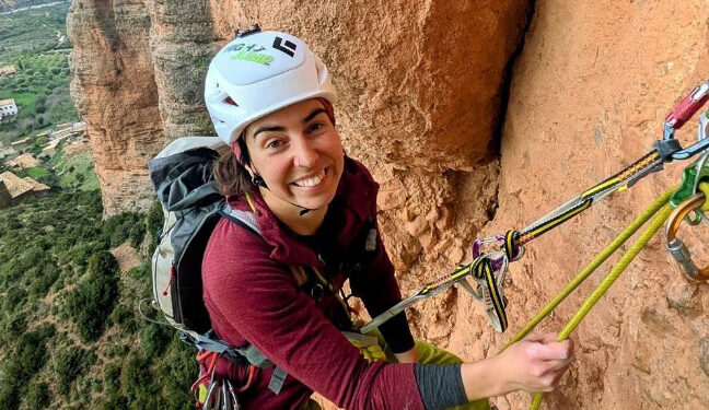 Mujer escalada en roca.