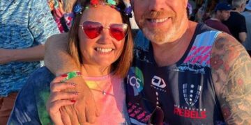 Foto de un hombre y una mujer sonriendo por la cámara.