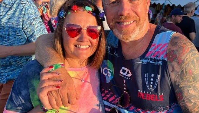 Foto de un hombre y una mujer sonriendo por la cámara.