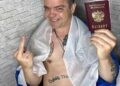 Hombre sosteniendo pasaporte ruso y dando el dedo medio.