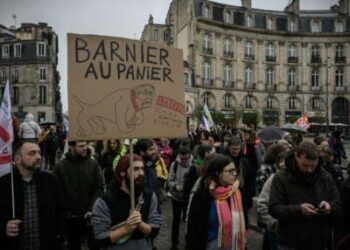 Un manifestante tiene una lectura de carteles "Barnier en la canasta, ten cuidado con el perro homofóbico y racista" Mientras marcha en una manifestación durante una huelga llamada por los sindicatos franceses para abrir un frente social en medio de una crisis política, el día después del gobierno del primer ministro Michel Barnier cayó en una moción de desconfianza, en Bordeaux, suroeste de Francia, el 5 de diciembre de 2024.