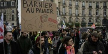 Un manifestante tiene una lectura de carteles "Barnier en la canasta, ten cuidado con el perro homofóbico y racista" Mientras marcha en una manifestación durante una huelga llamada por los sindicatos franceses para abrir un frente social en medio de una crisis política, el día después del gobierno del primer ministro Michel Barnier cayó en una moción de desconfianza, en Bordeaux, suroeste de Francia, el 5 de diciembre de 2024.
