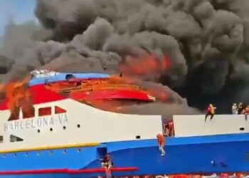 Ferry ardiente con gente saltando al océano.