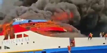 Ferry ardiente con gente saltando al océano.