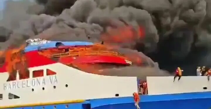 Ferry ardiente con gente saltando al océano.