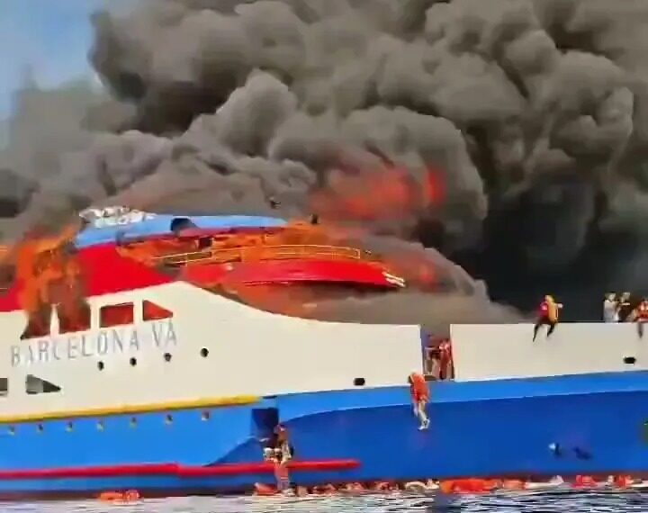 Ferry ardiente con gente saltando al océano.