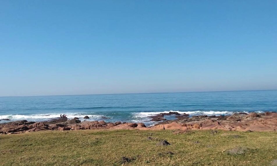 Vista oceánica desde el área cubierta de hierba con costa rocosa.