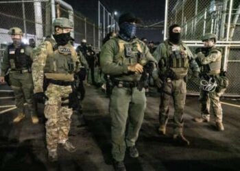 Los agentes de Inmigración y Control de Aduanas de los Estados Unidos (ICE) guardan afuera de Delaney Hall, un centro de detención de migrantes, mientras que los activistas anti-hielo lo demuestran el 12 de junio de 2025, en Newark, Nueva Jersey.