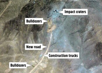 Vista aérea de la actividad de construcción que muestra excavadoras, camiones de construcción, una nueva carretera y cráteres de impacto.