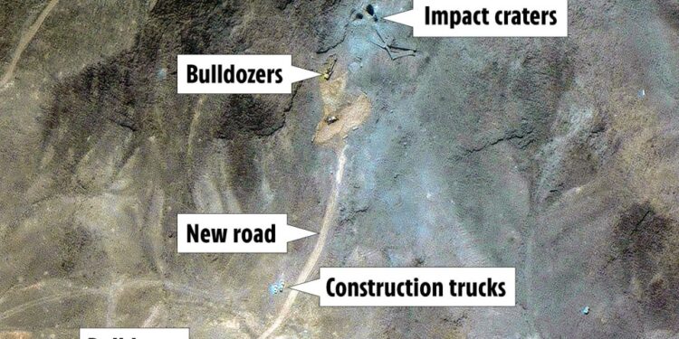 Vista aérea de la actividad de construcción que muestra excavadoras, camiones de construcción, una nueva carretera y cráteres de impacto.