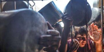 Los palestinos se alinean para la distribución de alimentos de caridad en la ciudad de Gaza