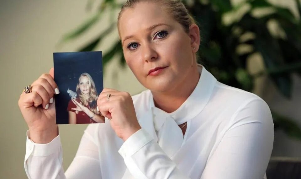 Mujer sosteniendo una foto de una mujer  joven con un pájaro.