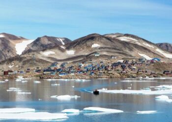 Kap Hope, Ittoqqortoormiit, Groenlandia, con coloridas casas y tallas de hielo en el agua.