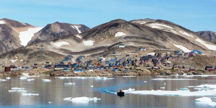Kap Hope, Ittoqqortoormiit, Groenlandia, con coloridas casas y tallas de hielo en el agua.
