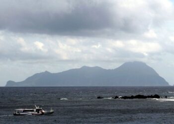 La isla de Akuseki, Japón, vio desde el mar con un bote.