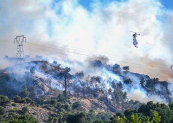 Helicóptero que cae agua en un incendio forestal.