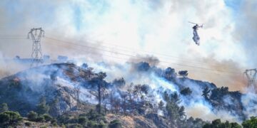 Helicóptero que cae agua en un incendio forestal.