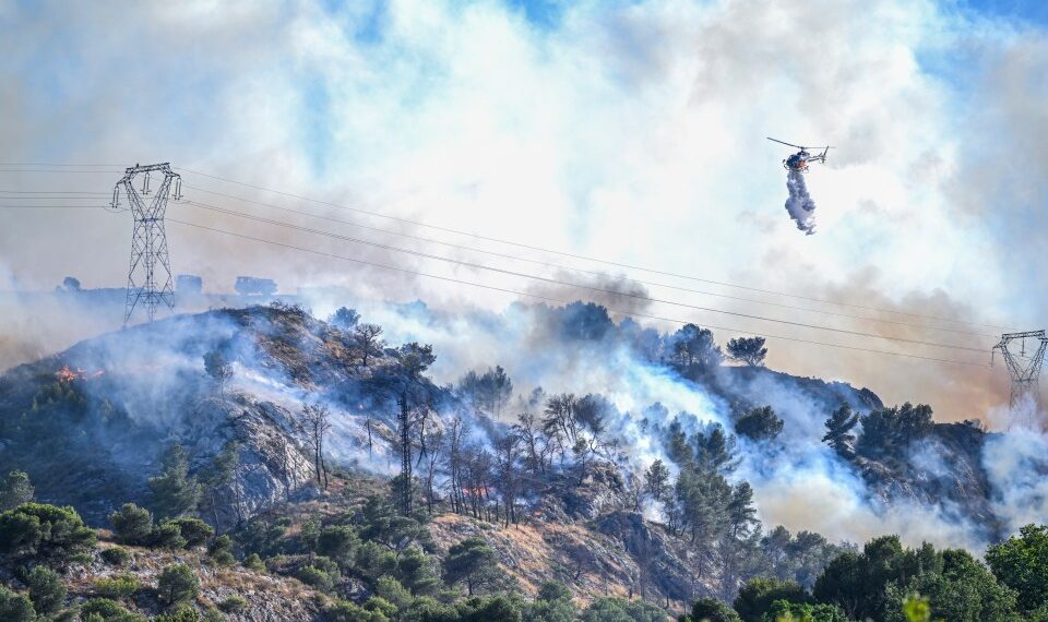 Helicóptero que cae agua en un incendio forestal.