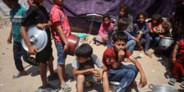 Los niños palestinos hacen cola para alimentos en un punto de distribución en la ciudad de Gaza, el 17 de junio de 2025.