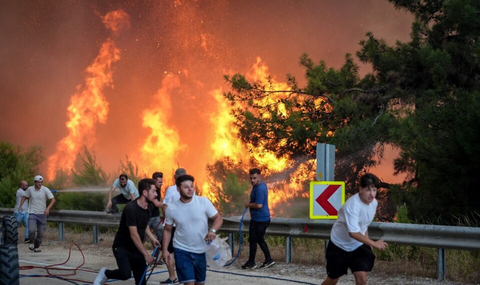 Bomberos y civiles que luchan contra un gran incendio forestal.