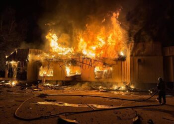 Un edificio envuelto en llamas por la noche.