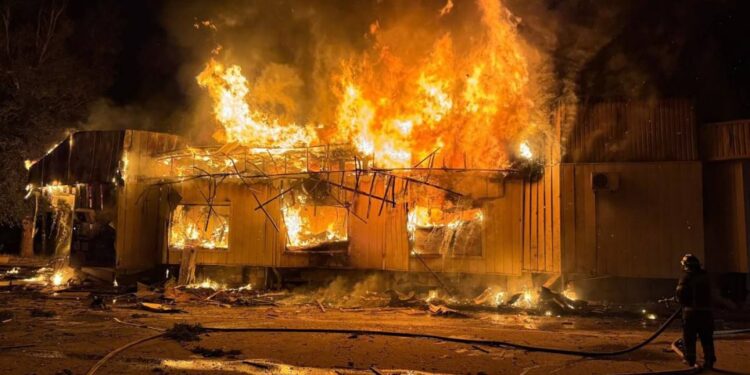Un edificio envuelto en llamas por la noche.