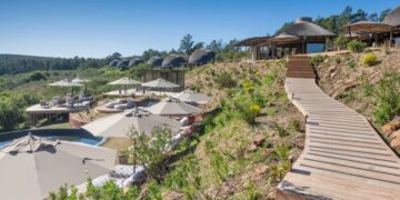 Gondwana Private Game Reserve Resort con una pasarela de madera y una piscina.