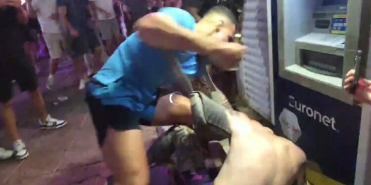 Un hombre con una camisa azul claro golpea a otro hombre durante una pelea en Magaluf.