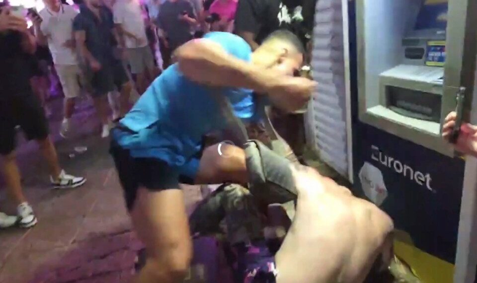 Un hombre con una camisa azul claro golpea a otro hombre durante una pelea en Magaluf.