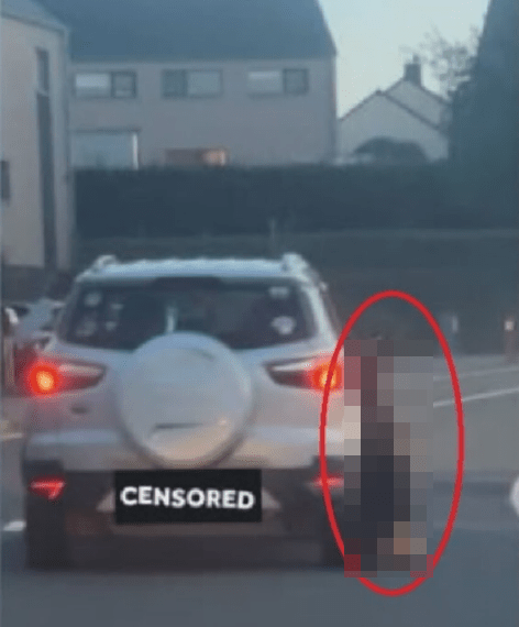 Una imagen borrosa de una persona parada cerca de la parte trasera de un automóvil.