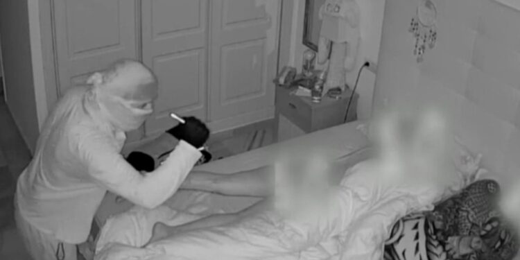 Imágenes de la cámara de seguridad de un ladrón mirando a una mujer dormida.
