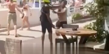 Oficial de policía abofeteando a un hombre durante una confrontación con los vendedores ambulantes.