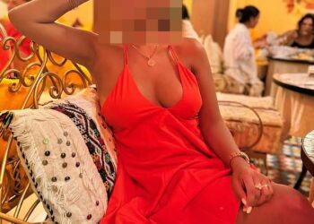 Mujer con vestido naranja con cara borrosa.