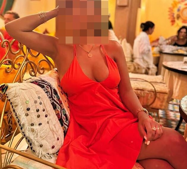 Mujer con vestido naranja con cara borrosa.