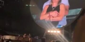 Pantalla grande que muestra una pareja que se abraza en un concierto de Coldplay.