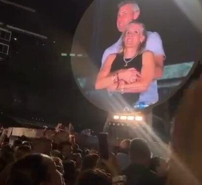 Pantalla grande que muestra una pareja que se abraza en un concierto de Coldplay.