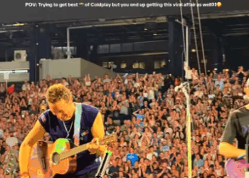 Chris Martin de Coldplay tocando la guitarra en el escenario.