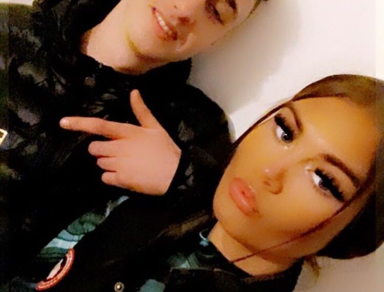 Foto de un joven y mujer posando juntos.