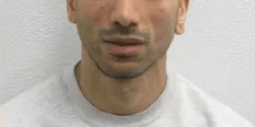 Hombre con peinado único con una sudadera con tres gatitos impresos.